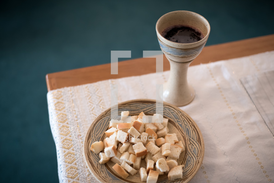 a chalice of wine and bowl of bread for communion 