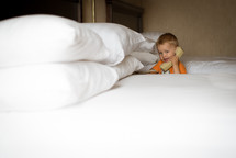 a little boy talking on a telephone in a hotel room 