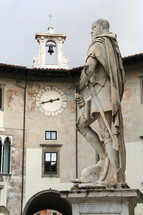 Soldier statue and clock tower and bell. Classical Italian art.