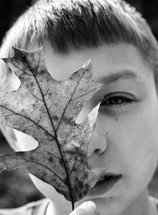 a boy holding up a leaf 