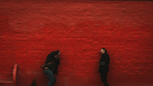 photographer taking a picture against a red wall 