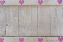 a border of pink hearts on wood background 