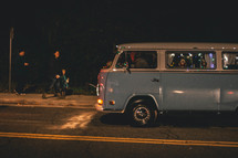 a VW van driving on a road at night 