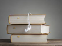 earbuds on a stack of books 