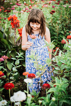 young lady smelling flowers in a blooming garden