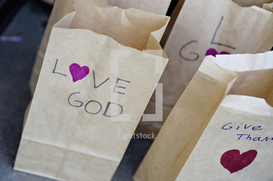 love God, give thanks, paper bags 