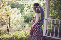 a couple walking holding hands through overgrown vegetation 