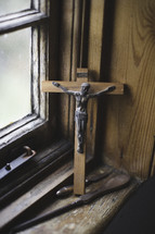 a wooden and metal crucifix in a window sill 