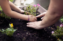 mother and daughter planting flowers 