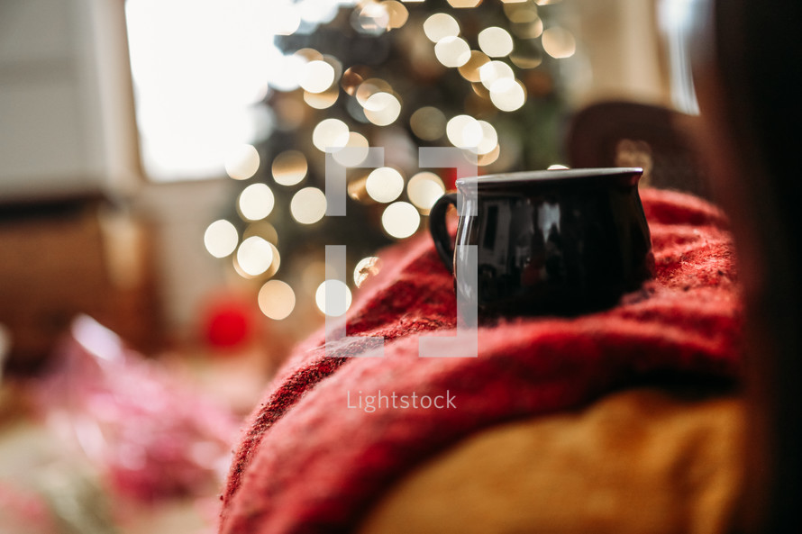 bokeh Christmas lights and mug on a wood table 