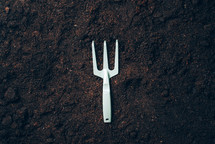 Gardening tools and utensils on soil background. Top view with copy space. Pruner, rake, shovel for garden manteinance. Summer season. Farming, landscaping concept