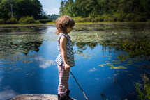 a girl playing at a pond 