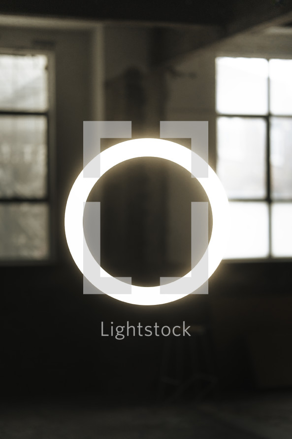 Floating halo ring light in and industrial warehouse building, abstract light photography