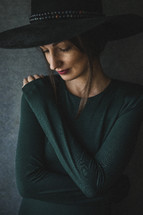 woman in a hat in studio looking down 