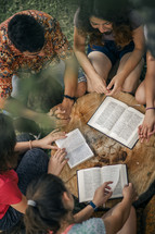 overhead view of a group of people reading Bibles in a circle 