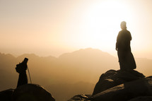 silhouettes exploring mountaintops under intense sunlight 