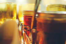 Glasses and jars of jam on a table.