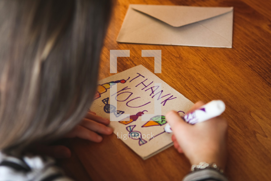 a child drawing a thank you card 