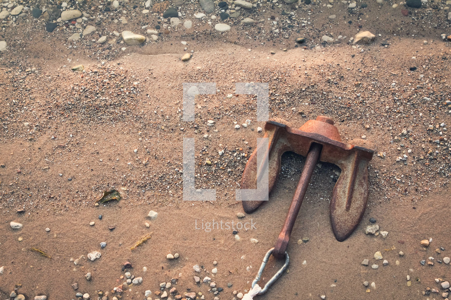 rusty anchor lying on the shore