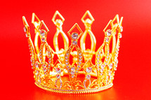 Small Golden Crown Isolated on a Red Background