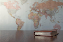 world map and Bible on a desk 