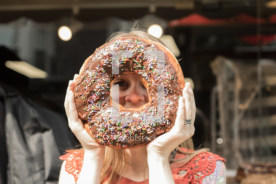 a woman holding up a giant donut 