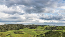 Fast motion clouds sky above green rural country pasture in New Zealand nature landscape Time lapse
