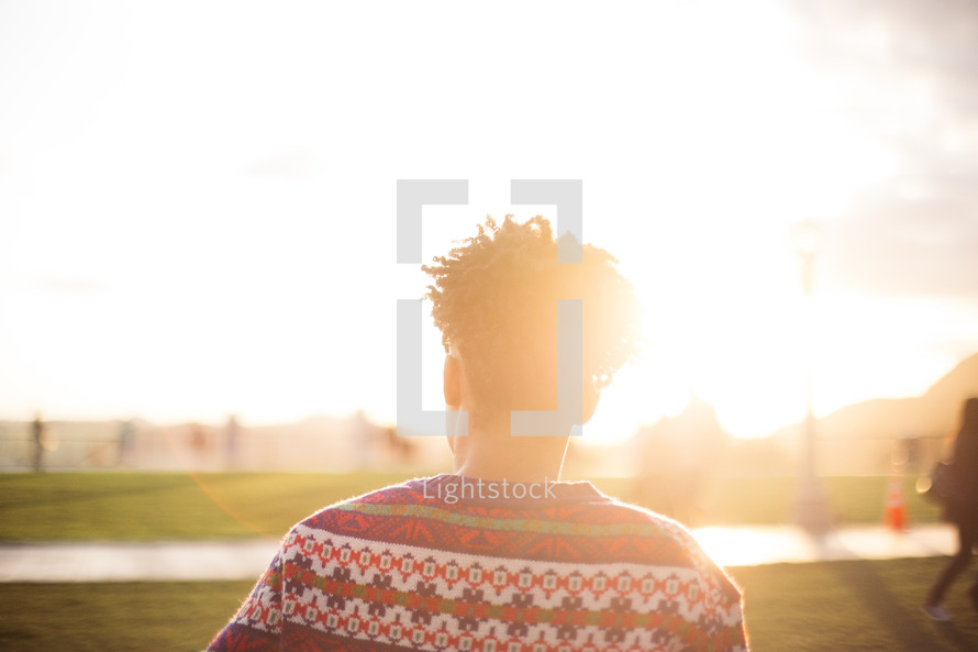 woman in a park taking in the views under the glow of sunlight 