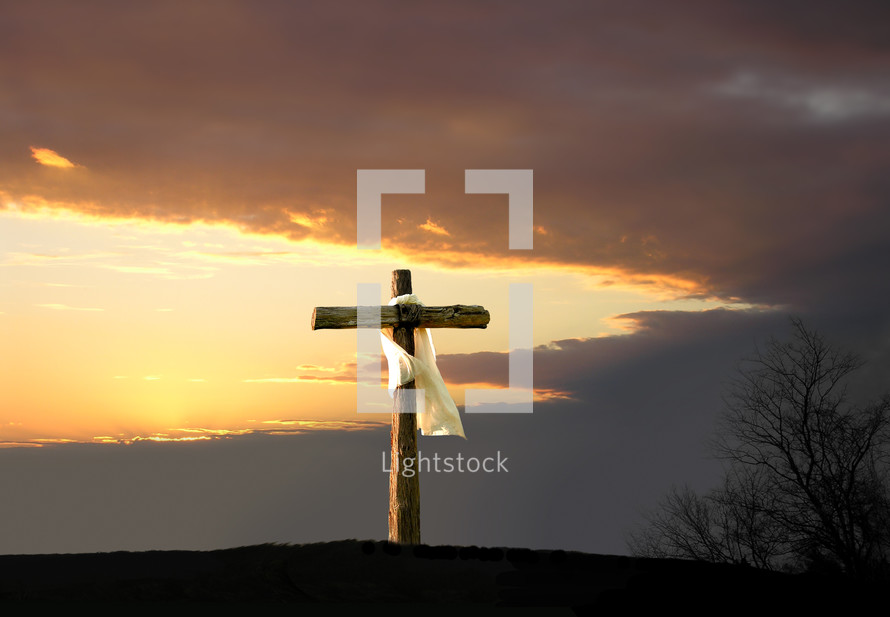 white shroud on a cross under a dramatic sky at sunset 
