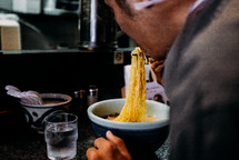 man eating noodles in a restaurant in Japan 
