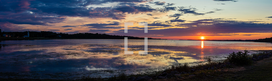panoramic view of a calm seascape shore at sunset 