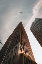 airplane flying above skyscrapers 