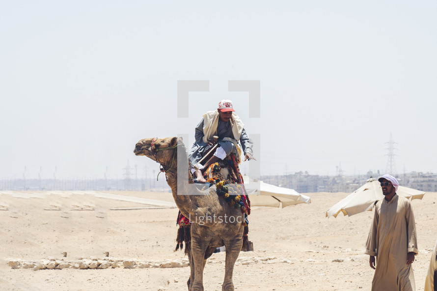 man riding a camel in the desert 