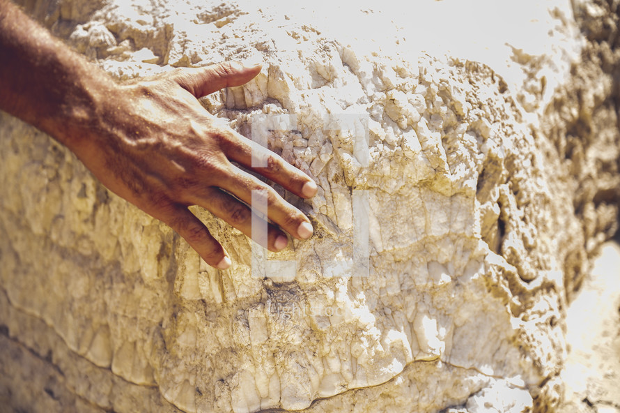 a man placing his hand on a sacred rock 