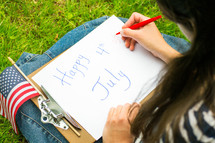 girl making a happy 4th of July sign 