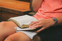 Person, sitting with a bible and notebook open on his lap