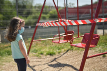 Alone Girl and Children's Swings Wrapped With Signal Tape