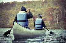man and woman paddling a canoe 