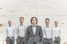 groom and groomsmen in suspenders and bow ties 