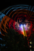spinning light from a fair ride at night 
