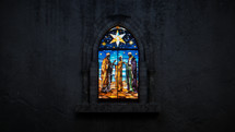 Wide shot of a beautiful, dimly back-lit stained glass window of Nativity Wisemen with snow just starting to fall. Stained glass was generated with AI and composited into a 3D CGI scene.