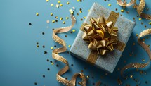 Elegant gift box with golden bow on a festive blue background