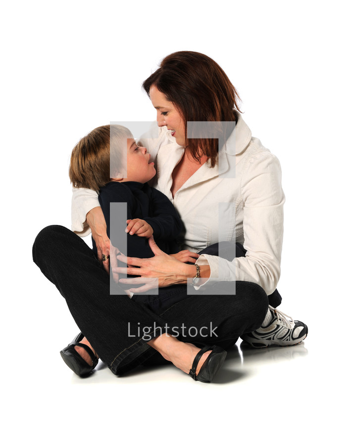 Woman sitting on the floor holding and hugging a young boy