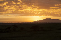 African sun rising from behind a mountain 