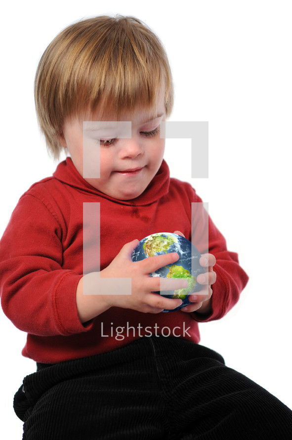 Young boy sitting on the floor holding a ball
