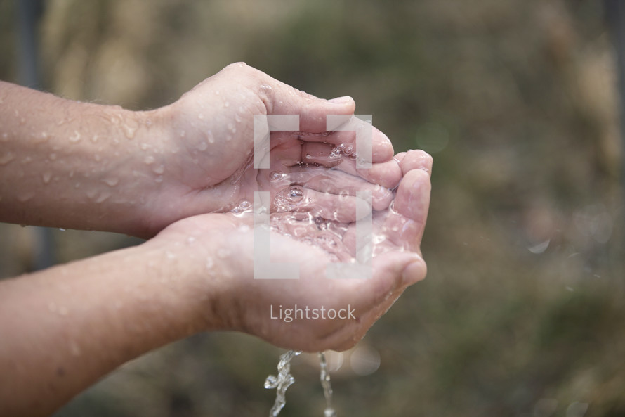 Mans hand cupped holding water