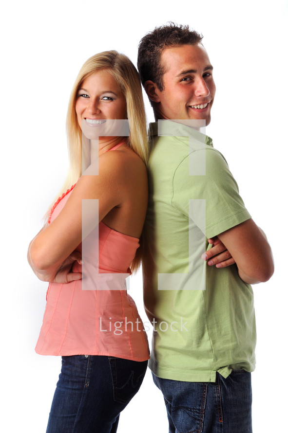 smiling young couple standing back to back