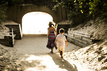 children running towards a tunnel 