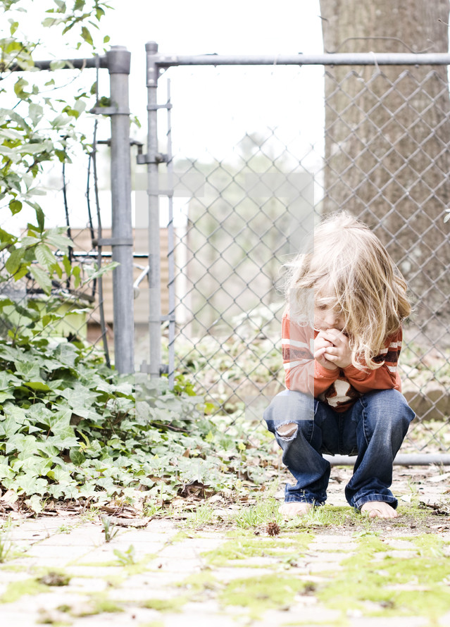 boy child in prayer outdoors
