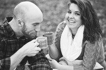 Couple enjoying coffee outside.